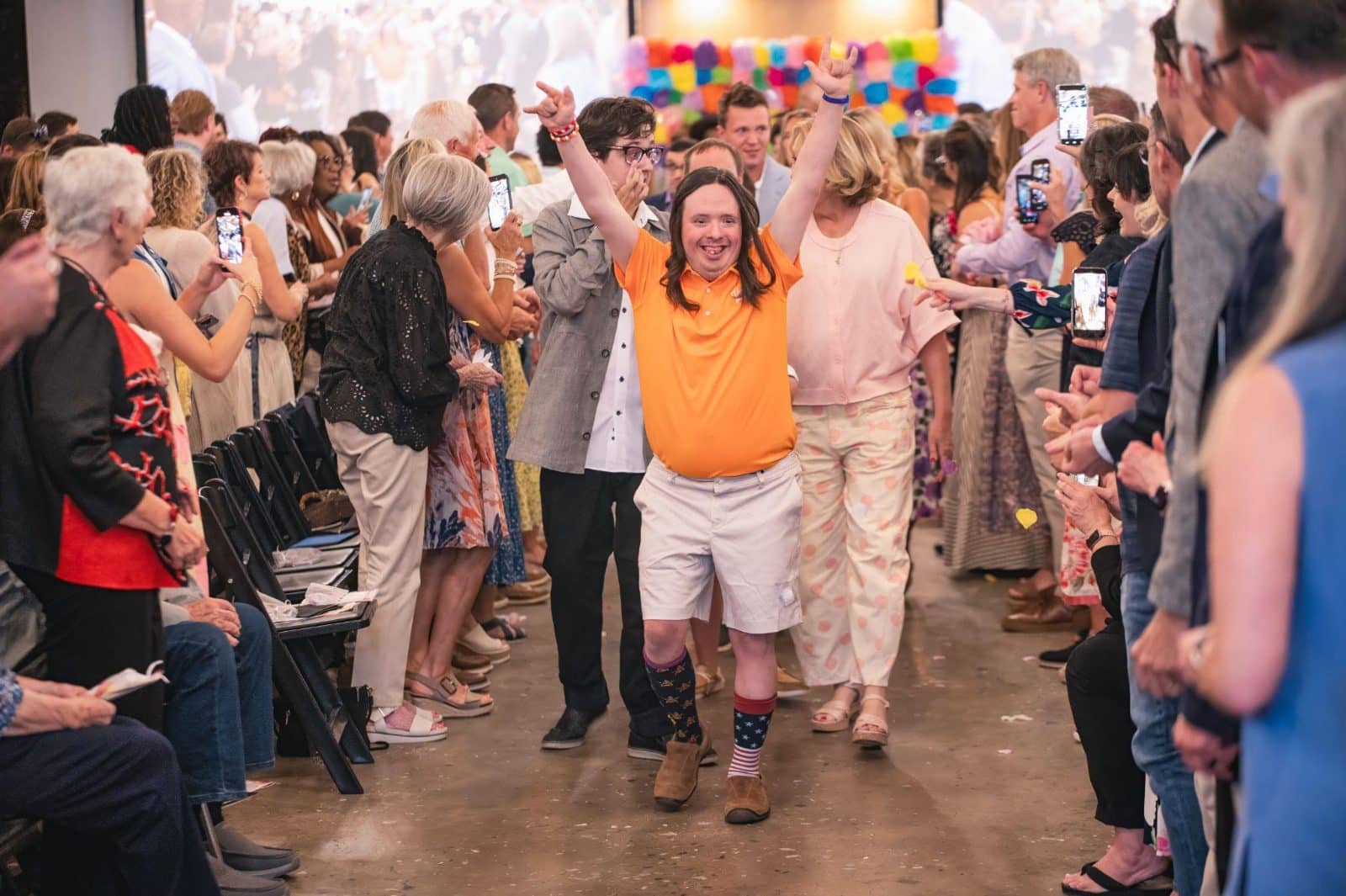 Koinonia participant celebrating while walking down an aisle of cheering supporters